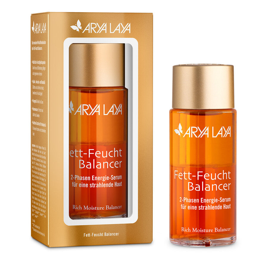 Arya Laya Fett-Feucht Balancer 2-Phasen Energie-Serum in einer goldfarbenen Verpackung mit Sichtfenster und eine einzelne Flasche daneben. Die transparente Flasche enthält orangefarbenes Serum und hat einen goldfarbenen Schraubverschluss.