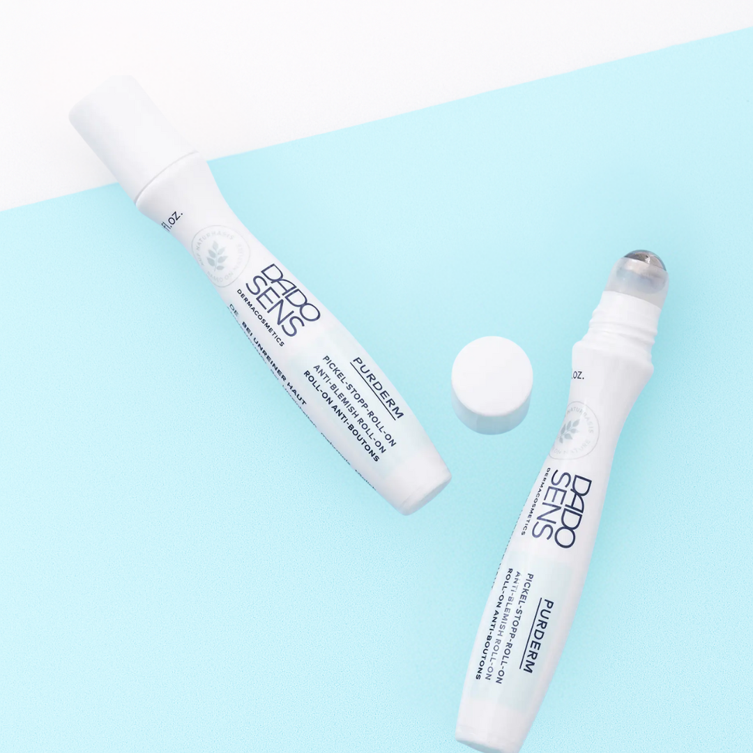 DADO SENS PURDERM Pickel-Stopp Roll-On 10 ml – Moodbild mit geöffnetem und geschlossenem Roller auf hellblauem Hintergrund