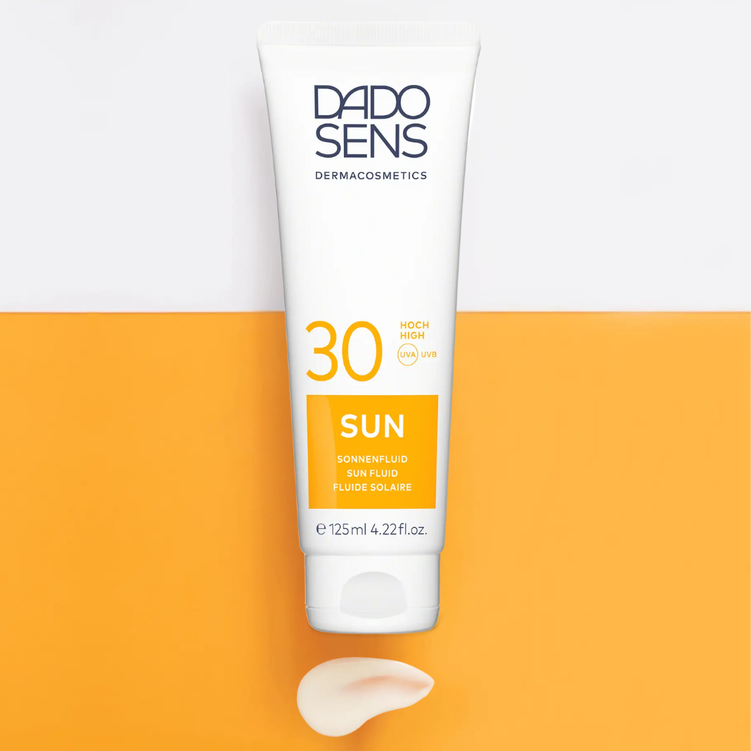 DADO SENS SUN Sonnenfluid LSF 30 – stylisch präsentiert auf zweifarbigem Untergrund mit Texturauftrag, sanfter UV-Schutz