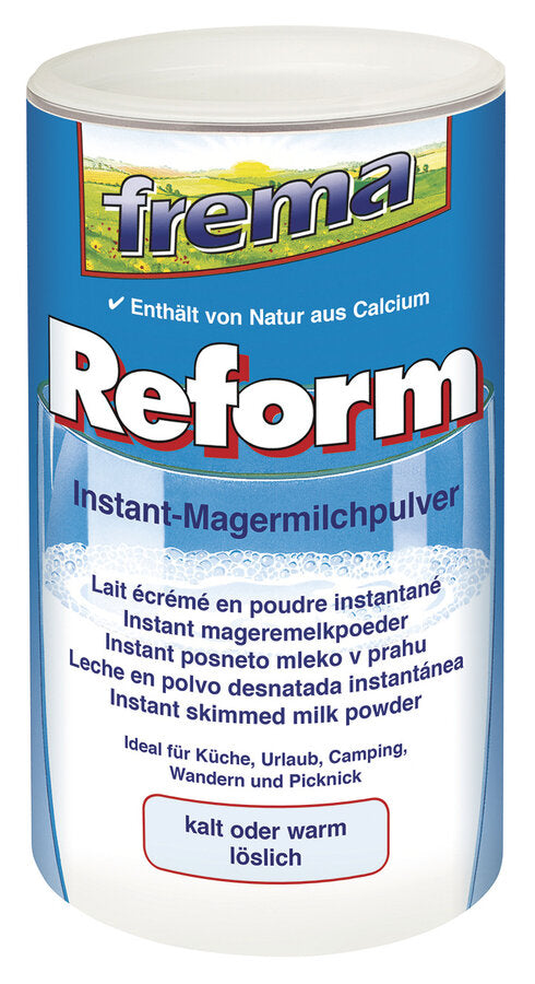 Eine blaue Dose des frema Reform Instant-Magermilchpulvers mit weißem Deckel. Auf der Verpackung steht „Enthält von Natur aus Calcium“ und „kalt oder warm löslich“. Die Dose zeigt ein Glas Milch mit Schaum und bietet Produktinformationen in mehreren Sprachen.