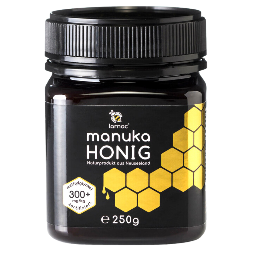 Ein Glas Larnac Manuka Honig MGO 300+ mit einem schwarzen Deckel. Das Etikett zeigt das Larnac-Logo, die Aufschrift "Manuka Honig", "Naturprodukt aus Neuseeland", und "methylglyoxal 300+ mg/kg zertifiziert", sowie eine goldene Wabenstruktur. Der Honig hat einen höheren MGO-Gehalt, was auf seine wirksamen antibakteriellen Eigenschaften hinweist und ihn besonders wertvoll für die Unterstützung der Gesundheit und das Immunsystem macht. Inhalt: 250 g