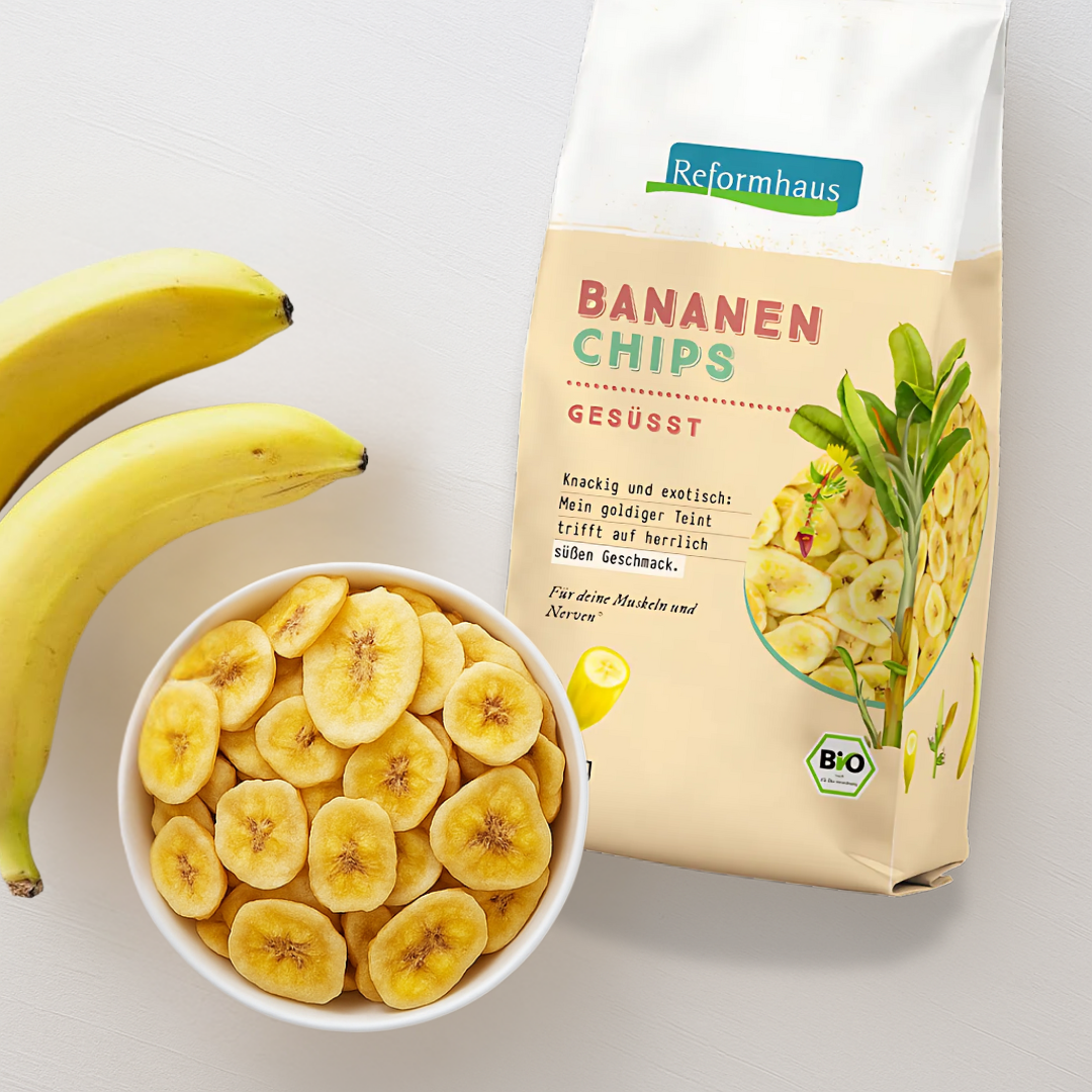 Reformhaus Bio Bananen Chips gesüßt – Serviervorschlag mit Schale, frischen Bananen und Produktverpackung auf hellem Hintergrund