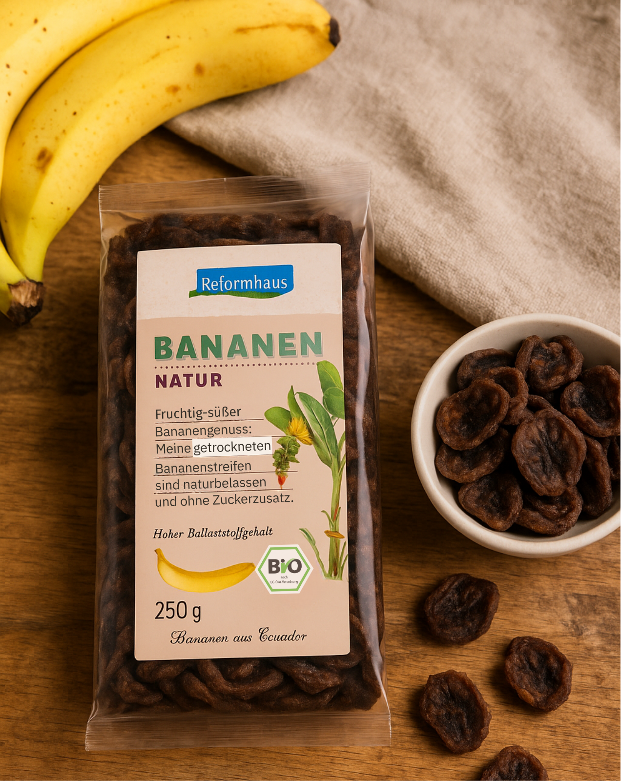 Reformhaus Bio-Bananen Natur 250 g im natürlichen Setting – getrocknete, ungezuckerte Bananenscheiben aus Ecuador mit frischen Bananen und Holzuntergrund.