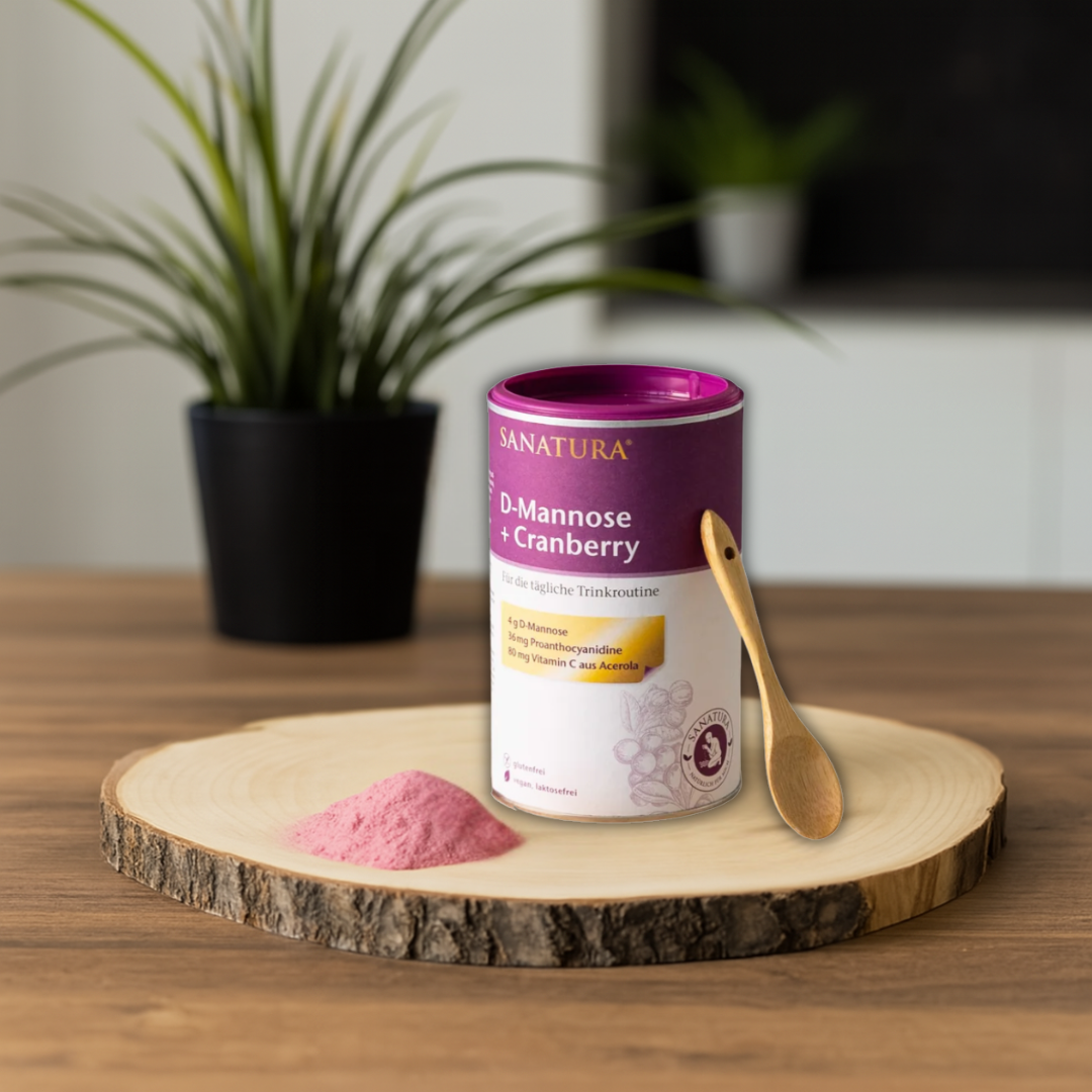 Sanatura D-Mannose + Cranberry Pulver – Dose mit rosa Pulver und Holzlöffel auf Holzunterlage, Nahrungsergänzung mit Proanthocyanidinen, Vitamin C und D-Mannose.