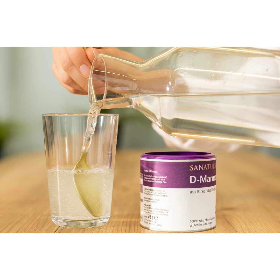 Sanatura D-Mannose in Anwendung – Glas mit Wasser und Löffel wird befüllt, daneben Dose mit D-Mannose-Pulver, ideal für die tägliche Einnahme in Flüssigkeit