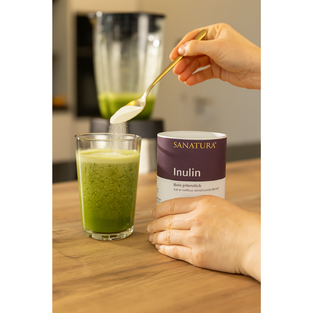 Sanatura Inulin Anwendung – Pulver wird mit Löffel in grünen Smoothie eingerührt, Dose im Vordergrund, ideal für Shakes, Joghurt oder Müsli
