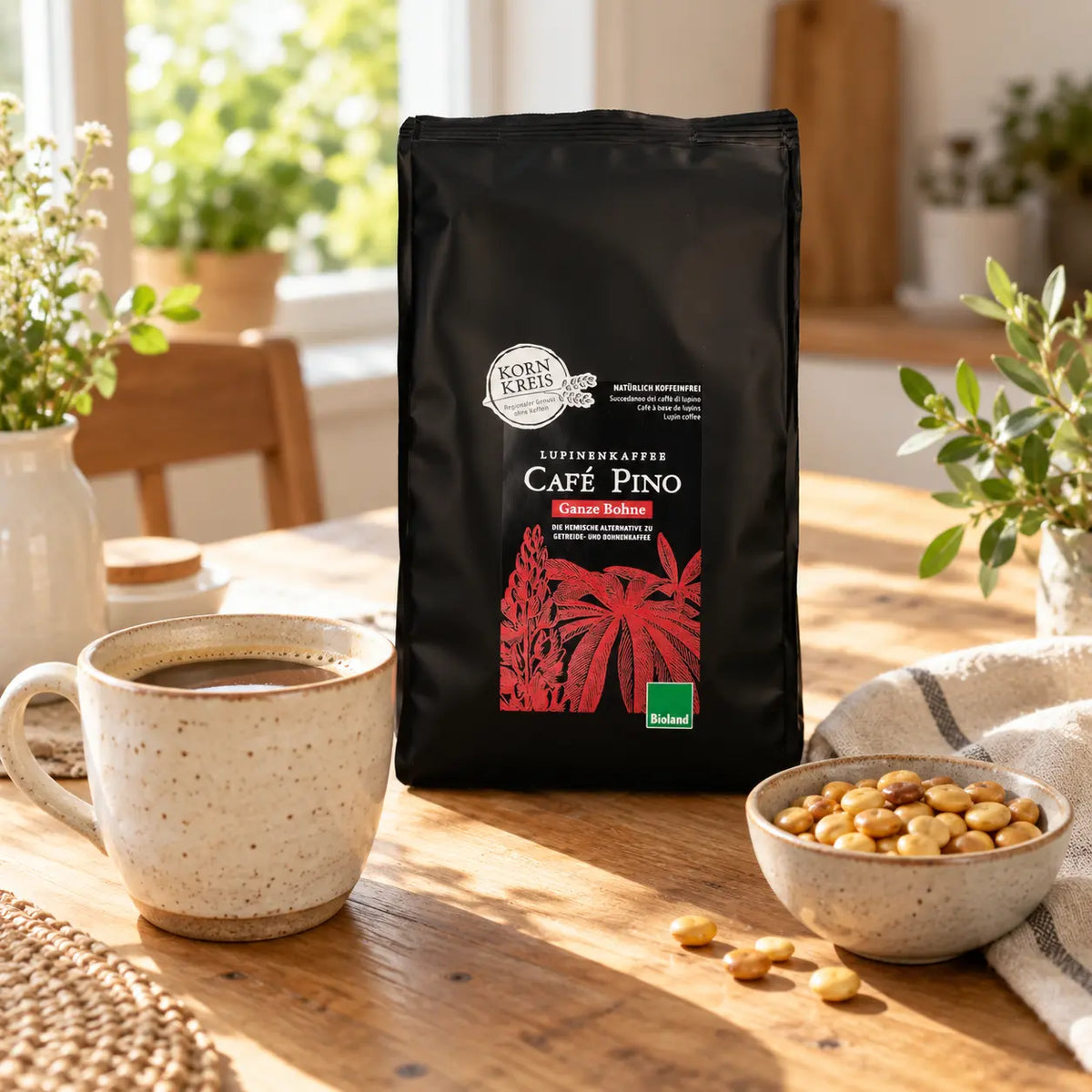 Packung Café Pino Ganze Bohne mit einer Tasse Lupinenkaffee auf dem Frühstückstisch