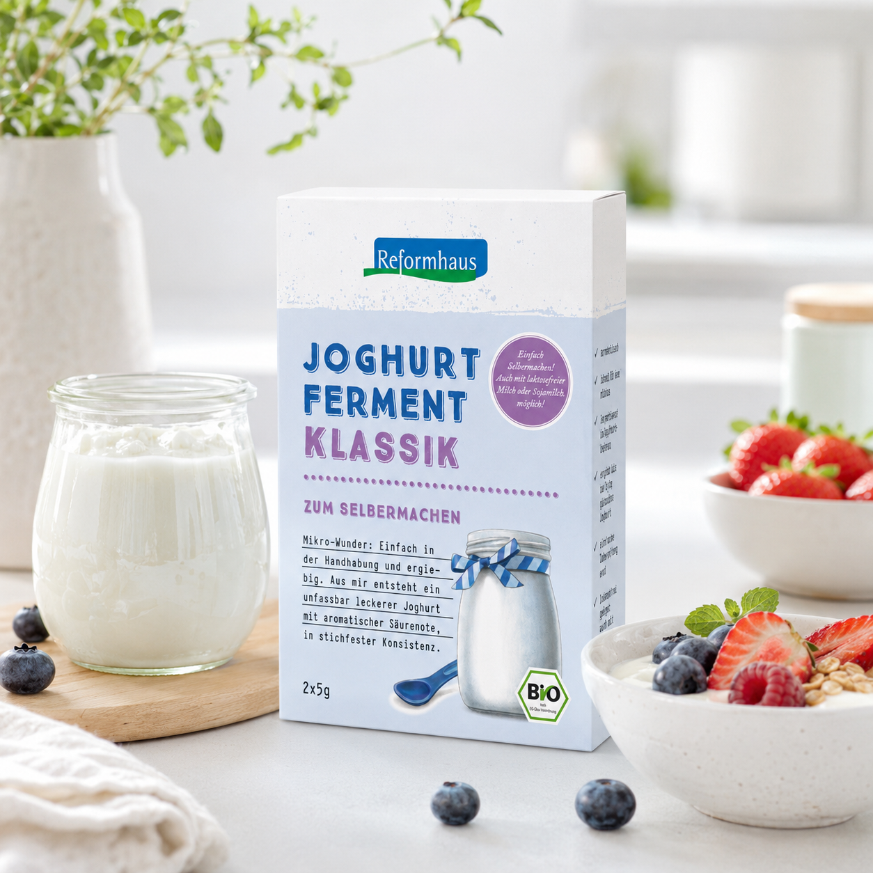 Reformhaus Joghurt-Ferment klassik bio neben selbstgemachtem Joghurt mit frischen Beeren in heller Küche