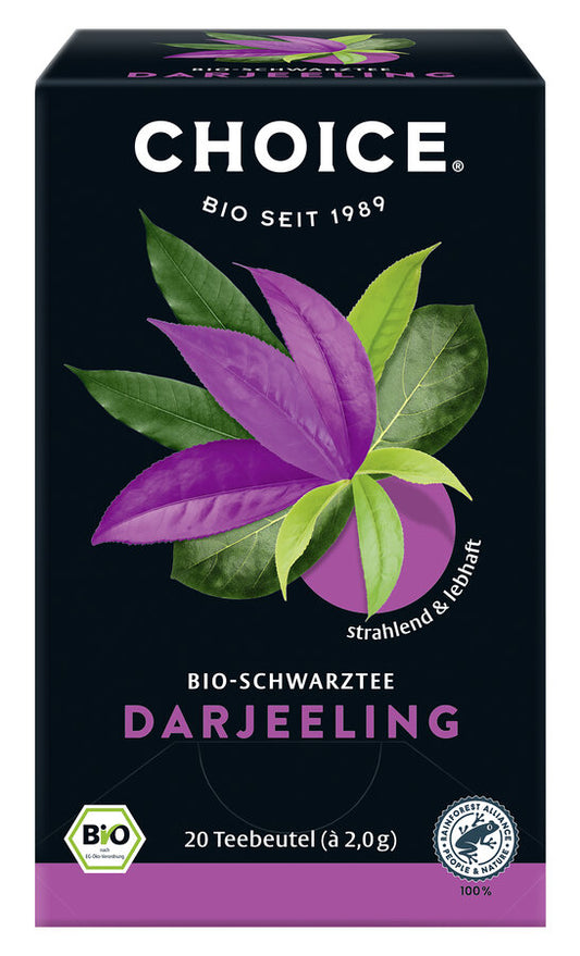 Eine Packung "Choice Bio-Schwarztee Darjeeling" von der Marke Choice. Auf der Vorderseite der Packung steht "Choice Bio seit 1989" und "Bio-Schwarztee Darjeeling". Das Etikett zeigt stilisierte Teeblätter in grün und lila, die den strahlenden und lebhaften Geschmack des Tees symbolisieren. Unten auf der Packung steht "strahlend & lebhaft". Die Packung enthält 20 Teebeutel mit jeweils 2,0 g Tee, insgesamt 40 g. Der Tee ist ein Bio-Produkt, wie durch das Bio-Siegel unten links angezeigt wird.