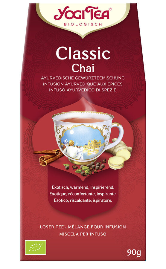 Eine Packung des 'Classic Chai' Tees von Yogi Tea. Die Verpackung ist rot und zeigt eine Illustration einer Tasse Tee mit einem orientalischen Motiv. Oben steht in roter Schrift 'Yogi Tea' und darunter 'Biologisch'. Die Teesorte ist als 'Ayurvedische Gewürzteemischung' beschrieben. Unten steht 'Exotisch, wärmend, inspirierend' in mehreren Sprachen. Es sind 90 g loser Tee enthalten. Unten links ist das europäische Bio-Siegel abgebildet.