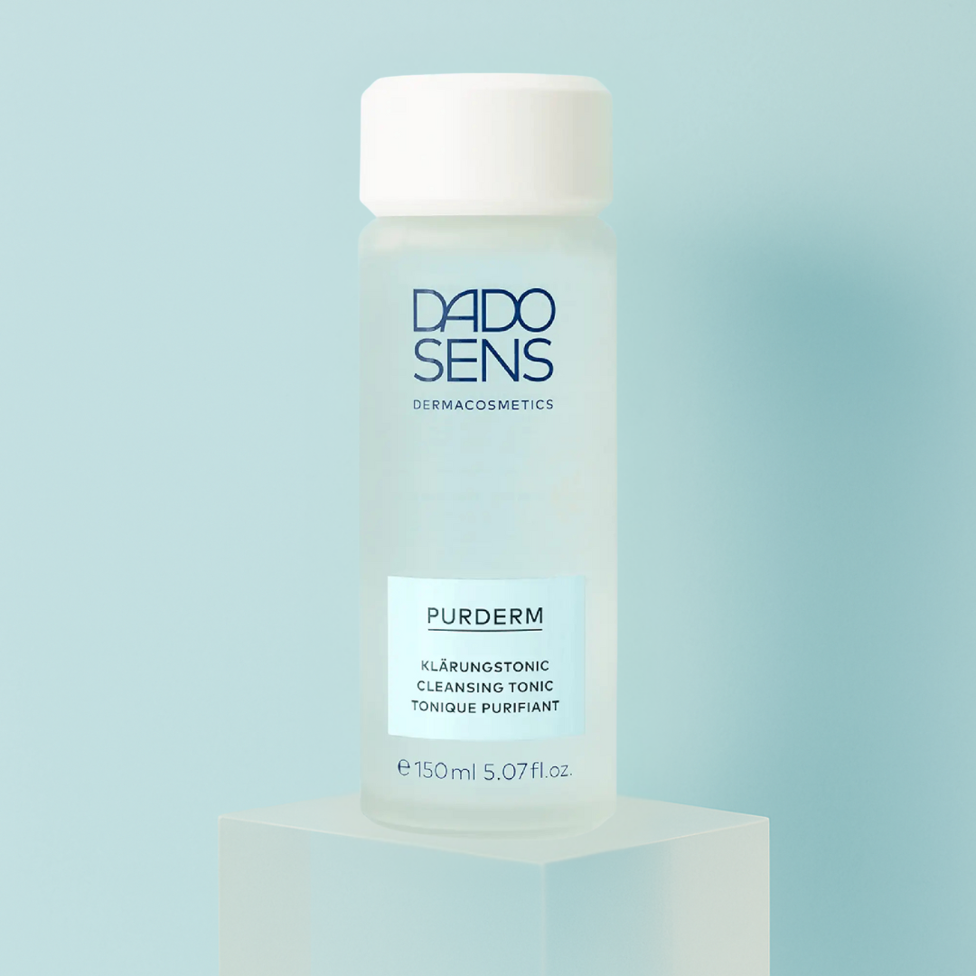 DADO SENS PURDERM Klärungstonic 150 ml – Moodbild mit Flasche auf hellblauem Podest für reine, gepflegte Haut