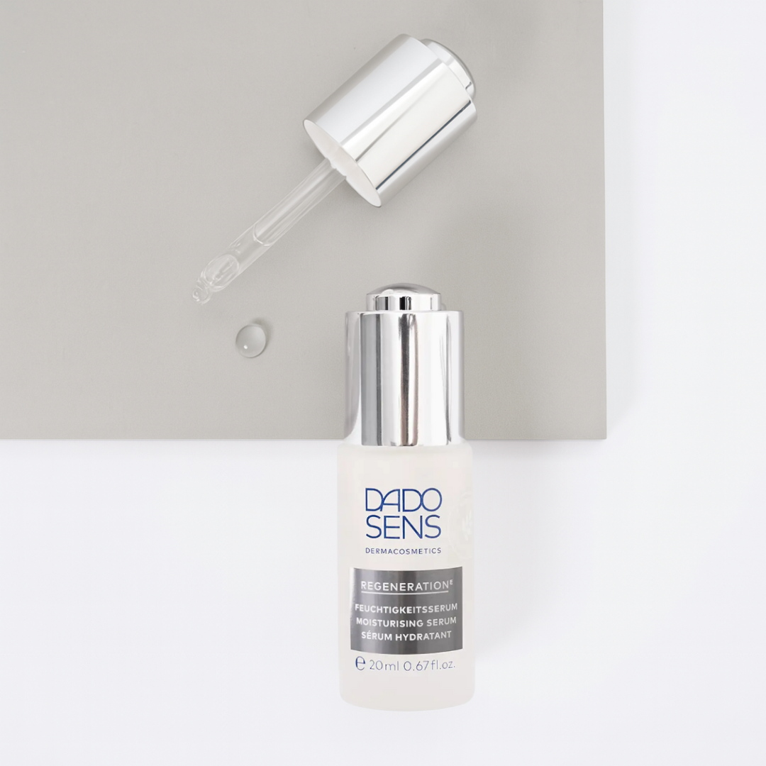 DADO SENS REGENERATION E Feuchtigkeitsserum 20 ml – Flatlay mit Glaspipette und Gel-Tropfen auf weiß-grauem Untergrund