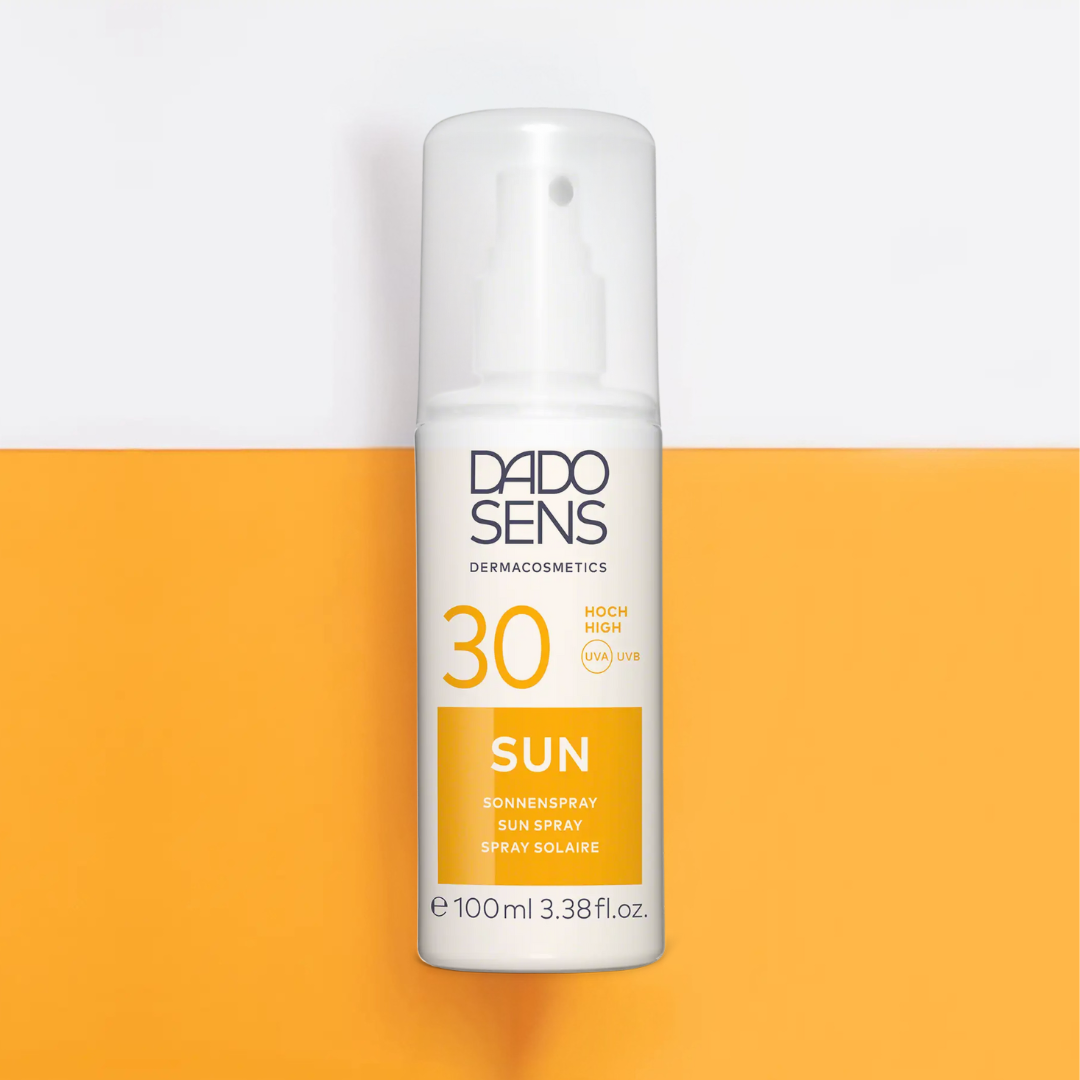 DADO SENS SUN Sonnenspray LSF 30 – modernes Produktfoto der Sprühflasche mit Lichtschutzfaktor 30, auf orange-weißem Hintergrund