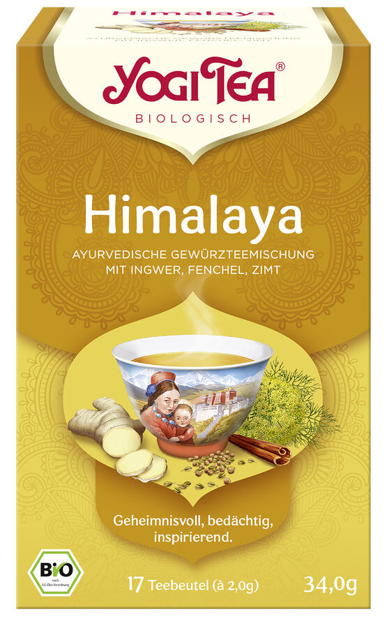 Eine Packung des 'Himalaya' Tees von Yogi Tea. Die Verpackung ist goldfarben und zeigt eine Illustration einer Tasse Tee mit einem Motiv aus dem Himalaya, umgeben von Ingwer, Fenchel und Zimt. Oben steht in roter Schrift 'Yogi Tea' und darunter 'Biologisch'. Die Teesorte ist als 'Ayurvedische Gewürzteemischung mit Ingwer, Fenchel, Zimt' beschrieben. Unten steht 'Geheimnisvoll, bedächtig, inspirierend'. Es sind 17 Teebeutel à 2,0 g enthalten, insgesamt 34,0 g. Unten links ist das Bio-Siegel abgebildet.