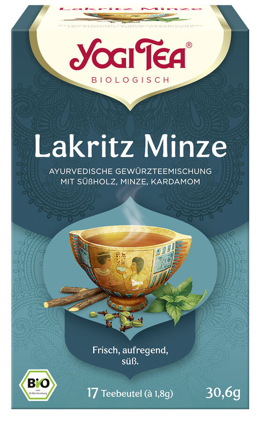 Eine Packung des 'Lakritz Minze' Tees von Yogi Tea. Die Verpackung ist dunkelblau und zeigt eine Illustration einer Tasse Tee mit einem ägyptischen Motiv, umgeben von Süßholzwurzeln, Minzblättern und Kardamomkapseln. Oben steht in roter Schrift 'Yogi Tea' und darunter 'Biologisch'. Die Teesorte ist als 'Ayurvedische Gewürzteemischung mit Süßholz, Minze, Kardamom' beschrieben. Unten steht 'Frisch, aufregend, süß'. Es sind 17 Teebeutel à 1,8 g enthalten, insgesamt 30,6 g. Unten links ist das Bio-Siegel