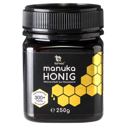 Ein Glas Larnac Manuka Honig MGO 300+ mit einem schwarzen Deckel. Das Etikett zeigt das Larnac-Logo, die Aufschrift "Manuka Honig", "Naturprodukt aus Neuseeland", und "methylglyoxal 300+ mg/kg zertifiziert", sowie eine goldene Wabenstruktur. Der Honig hat einen höheren MGO-Gehalt, was auf seine wirksamen antibakteriellen Eigenschaften hinweist und ihn besonders wertvoll für die Unterstützung der Gesundheit und das Immunsystem macht. Inhalt: 250 g
