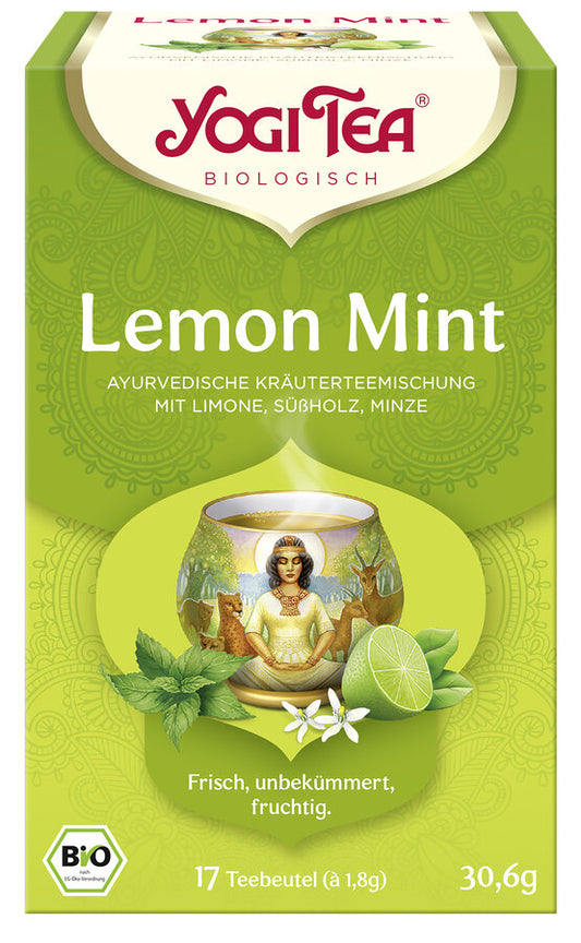 Eine Packung des 'Lemon Mint' Tees von Yogi Tea. Die Verpackung ist grün und zeigt eine Illustration einer Tasse Tee mit einem Motiv einer meditierenden Frau inmitten von Tieren, umgeben von Minzblättern, Limettenhälften und einer Blüte. Oben steht in roter Schrift 'Yogi Tea' und darunter 'Biologisch'. Die Teesorte ist als 'Ayurvedische Kräuterteemischung mit Limone, Süßholz, Minze' beschrieben. Unten steht 'Frisch, unbekümmert, fruchtig'. Es sind 17 Teebeutel à 1,8 g enthalten, insgesamt 30,6 g.