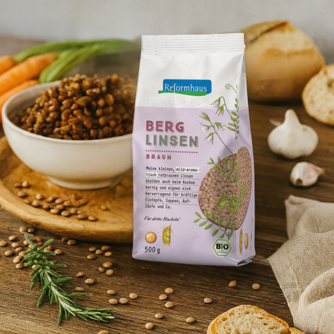 Bio Berglinsen Braun von Reformhaus neben gekochten Linsen und frischem Gemüse – ideales Produkt für Eintöpfe und Suppen