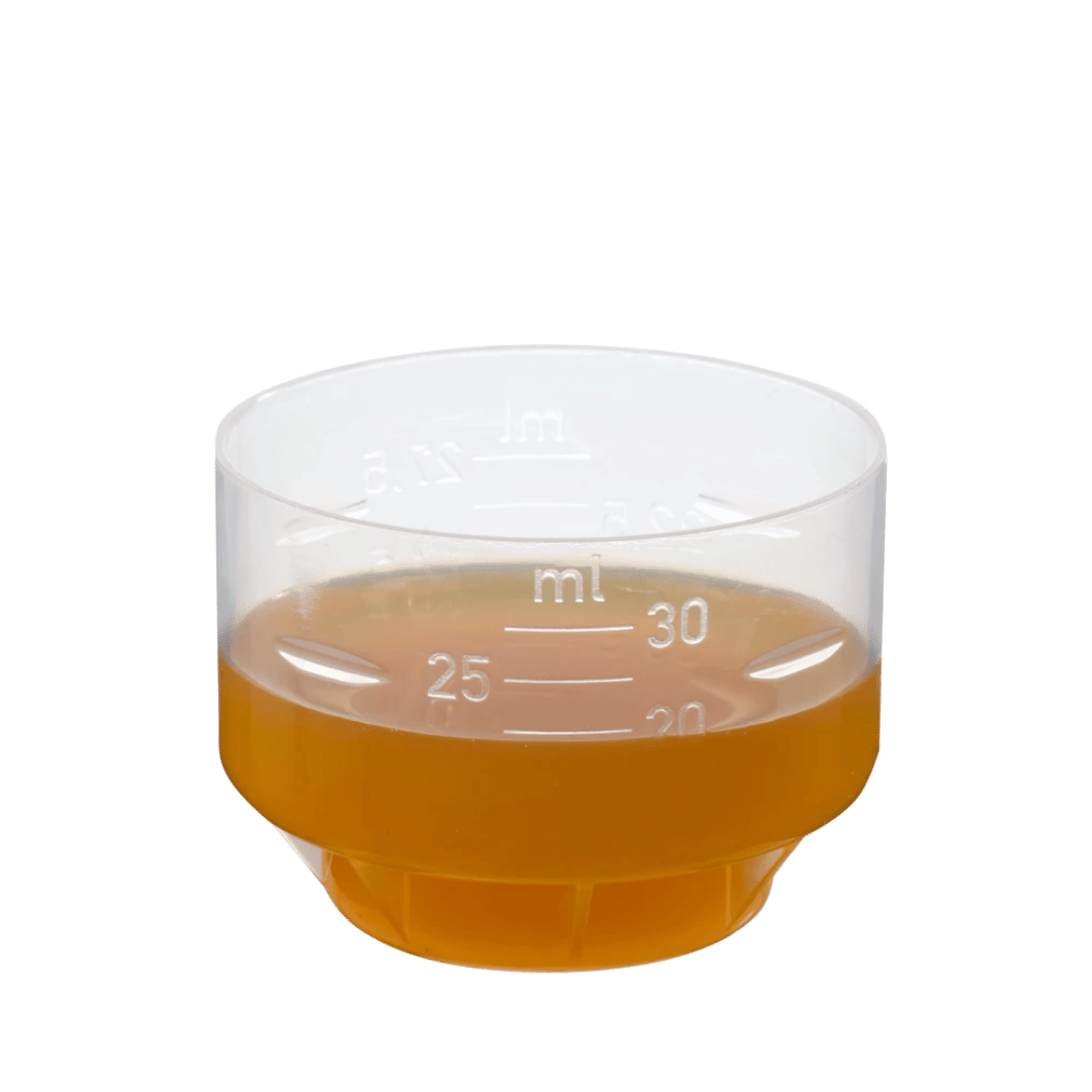 Dosierbecher mit Salus Magnesium Mineral-Drink – 30 ml orangefarbene Flüssigkeit