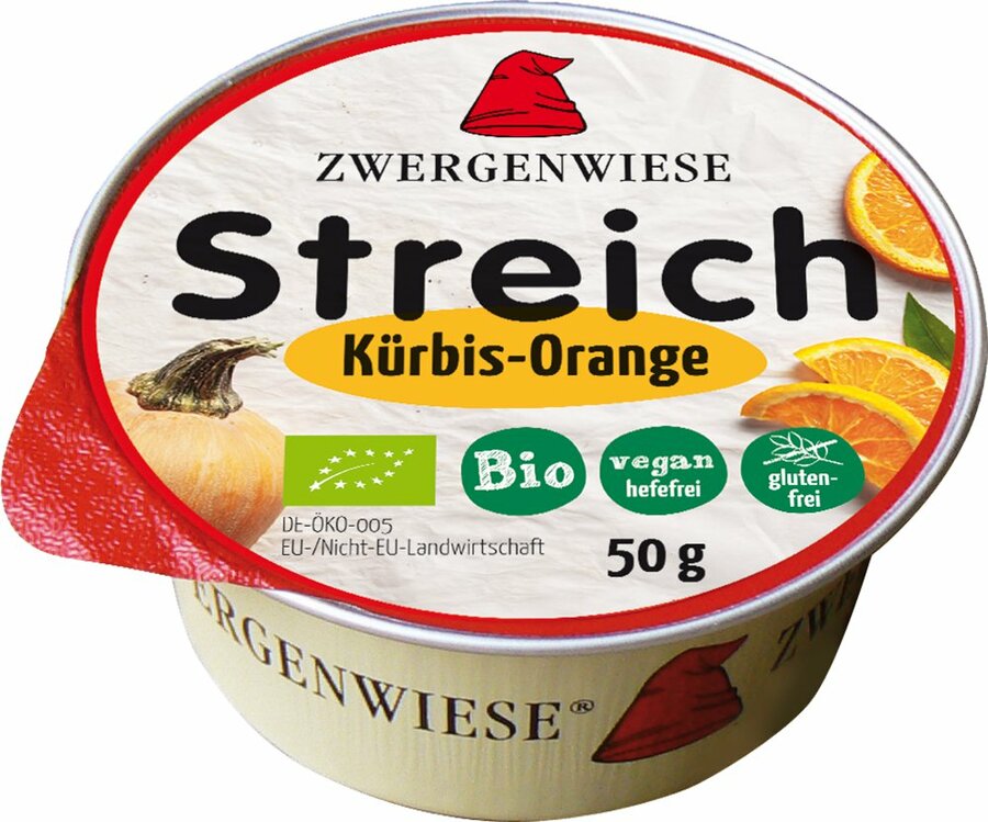 Das Bild zeigt eine runde, vegane Brotaufstrich-Dose der Marke Zwergenwiese. Die Dose hat einen roten Deckelrand und eine weiße Oberseite mit der Aufschrift "Zwergenwiese Streich Kürbis-Orange". Unterhalb des Produktnamens stehen mehrere Symbole, die das Produkt als bio, vegan (hefefrei) und glutenfrei kennzeichnen. Die Nettofüllmenge beträgt 50 Gramm. Auf dem Deckel sind außerdem Abbildungen eines Kürbisses und von Orangenscheiben zu sehen.