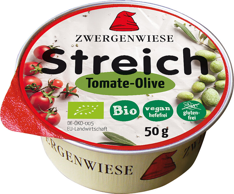 Eine runde Verpackung des Bio-Aufstrichs "Streich Tomate-Olive" von Zwergenwiese. Das Etikett zeigt eine rote Zwergenmütze, Tomaten und Oliven. Der Aufstrich ist vegan, hefefrei und glutenfrei. Das Produkt wiegt 50 g.