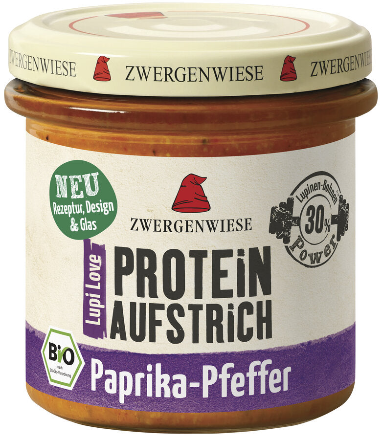 Das Bild zeigt ein Glas des veganen Proteinaufstrichs "Lupi Love Protein Aufstrich Paprika-Pfeffer" von Zwergenwiese. Der Deckel ist beige mit einem roten Zwergenhut. Das Etikett ist weiß und lila, mit der Aufschrift "PROTEIN AUFSTRICH Paprika-Pfeffer", "Bio" und einem Hinweis auf 30% Lupinen-Protein.