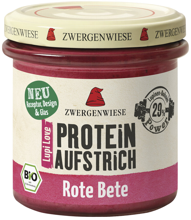 Das Bild zeigt ein Glas des veganen Proteinaufstrichs "Lupi Love Protein Aufstrich Rote Bete" von Zwergenwiese. Der Deckel ist beige mit einem roten Zwergenhut. Das Etikett ist weiß und rosa, mit der Aufschrift "PROTEIN AUFSTRICH Rote Bete", "Bio" und einem Hinweis auf 29% Lupinen-Protein.