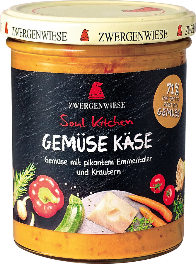 Das Bild zeigt ein Glas "Gemüse Käse" von Zwergenwiese aus der "Soul Kitchen" Reihe. Der Deckel ist beige mit einem roten Zwergenhut. Das Etikett ist schwarz und zeigt die Aufschrift "Zwergenwiese Soul Kitchen Gemüse Käse" in weißer und roter Schrift. Darunter steht "Gemüse mit pikantem Emmentaler und Kräutern". Auf dem Etikett sind außerdem Abbildungen von Paprika, Zucchini, Käse, Karotten und weiteren Gemüsesorten zu sehen. Ein gelbes Siegel auf dem Etikett weist auf einen 71% Gemüseanteil hin.