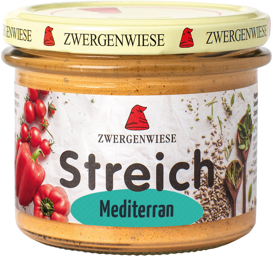 Ein Glas mit dem verlockenden Bio-Aufstrich "Streich Mediterran" von Zwergenwiese. Das Etikett präsentiert eine rote Zwergenmütze sowie frische Tomaten und Paprika. Der mediterrane Aufstrich ist vegan, hefefrei und glutenfrei, was ihn zu einer ausgezeichneten Wahl für gesundheitsbewusste Genießer macht. Der beige Deckel ist mehrfach mit dem Zwergenwiese-Logo bedruckt, was dem Produkt ein charmantes und einladendes Aussehen verleiht. Perfekt für eine bewusste und geschmackvolle Ernährung!