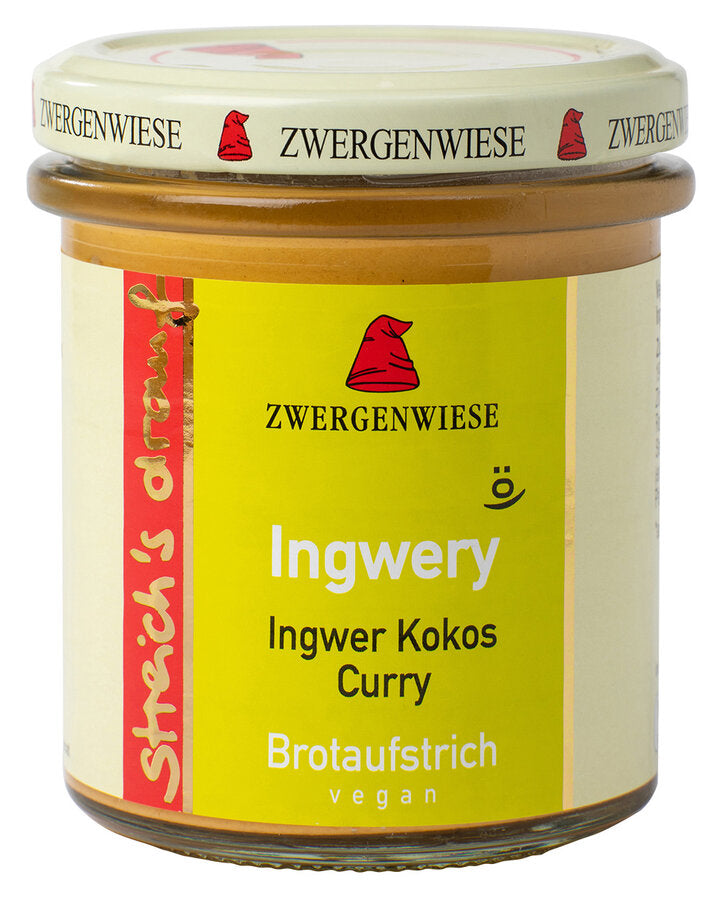 Das Bild zeigt ein Glas "Ingwery" Brotaufstrich von Zwergenwiese. Der Deckel ist beige mit einem roten Zwergenhut. Das Etikett ist gelb und zeigt die Aufschrift "Zwergenwiese Ingwery" in weißer Schrift. Darunter steht "Ingwer Kokos Curry". An der Seite des Etiketts steht "Streich's drauf" in gelber Schrift auf rotem Hintergrund. Der Brotaufstrich ist vegan.