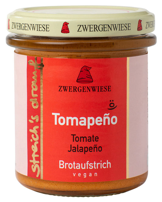 Ein Glas mit einem roten Aufstrich von der Marke Zwergenwiese. Auf dem Etikett steht "Tomapeño" und "Tomate Jalapeño". Der Aufstrich ist vegan und wird als "Brotaufstrich" bezeichnet. Das Etikett zeigt eine rote Zwergenmütze.