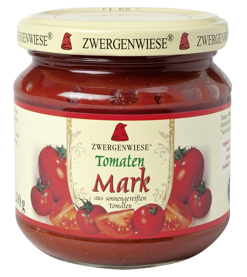 Ein Glas mit Tomatenmark von der Marke Zwergenwiese. Das Etikett zeigt eine rote Zwergenmütze und die Aufschrift "Tomaten Mark - aus sonnengereiften Tomaten". Um das Etikett herum sind frische Tomaten abgebildet, die die Qualität und Frische des Produkts hervorheben. Der beige Deckel trägt mehrfach das Zwergenwiese-Logo. Das Glas hat einen Inhalt von 200 g. Ideal für die Zubereitung von Saucen und anderen Tomatengerichten.