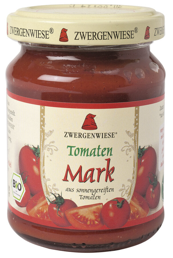 Ein Glas mit Bio-Tomatenmark von der Marke Zwergenwiese. Das Etikett zeigt eine rote Zwergenmütze und die Aufschrift "Tomaten Mark - aus sonnengereiften Tomaten". Um das Etikett herum sind frische Tomaten abgebildet, die die hohe Qualität und Frische des Produkts betonen. Der beige Deckel trägt mehrfach das Zwergenwiese-Logo. Dieses Bio-Tomatenmark eignet sich hervorragend für die Zubereitung von Saucen und anderen köstlichen Tomatengerichten.