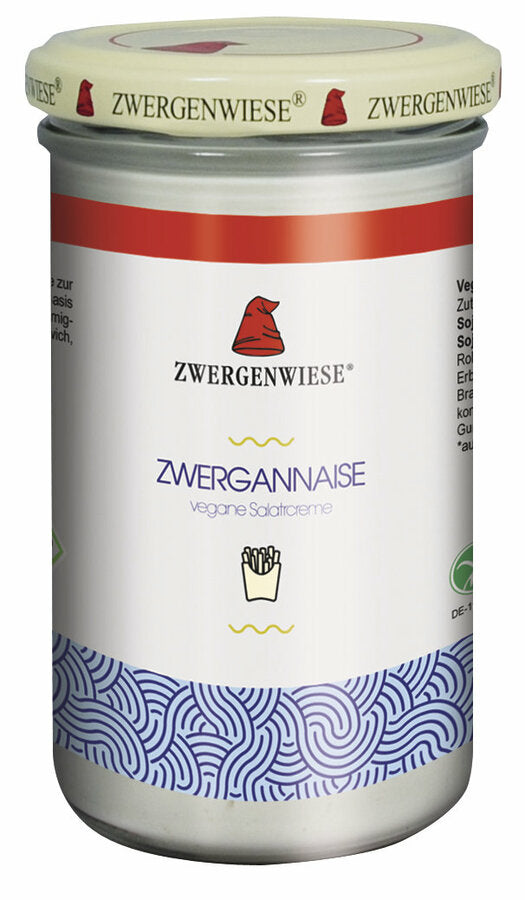 Ein Glas mit der veganen Salatcreme "Zwergannaise" von der Marke Zwergenwiese. Das Etikett zeigt eine rote Zwergenmütze und die Aufschrift "Zwergannaise - vegane Salatcreme". Am unteren Rand des Etiketts befindet sich ein blaues, wellenförmiges Muster. Der beige Deckel trägt mehrfach das Zwergenwiese-Logo. Diese vegane Salatcreme eignet sich hervorragend als Basis für Salatdressings oder als Brotaufstrich und bietet einen cremigen, vielseitigen Geschmack für zahlreiche Gerichte.