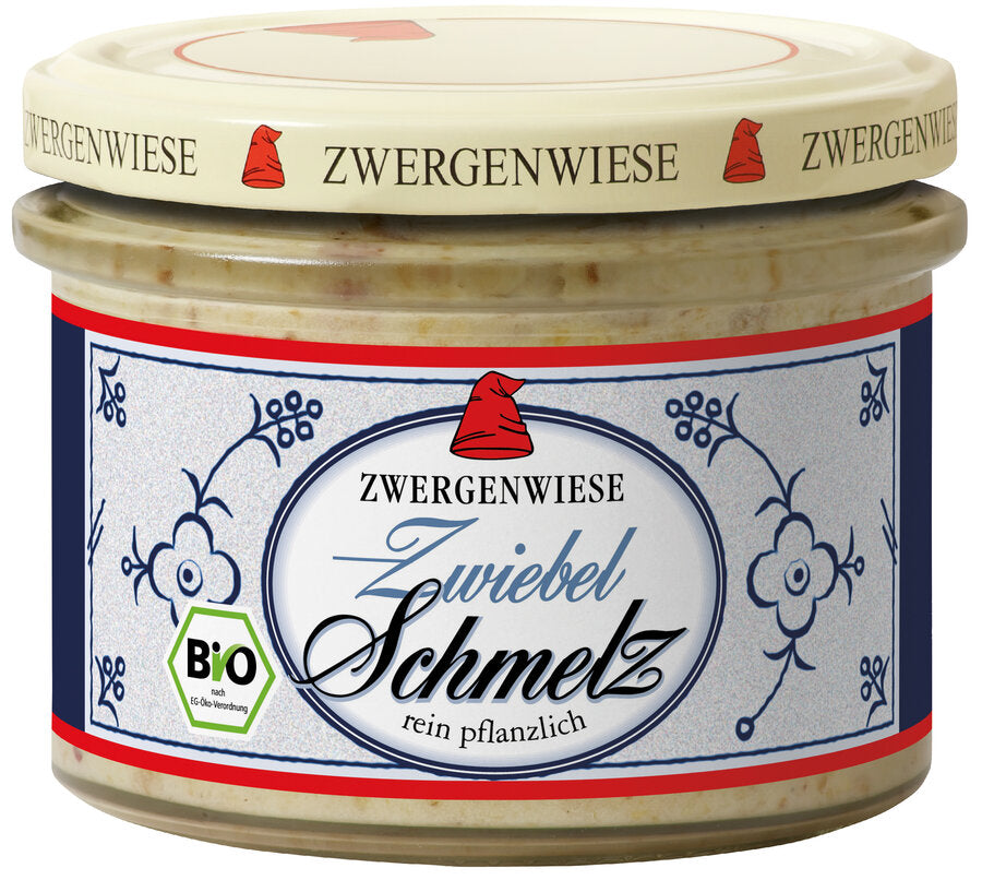 Ein Glas mit dem Bio-"Zwiebel Schmelz" von der Marke Zwergenwiese. Das Etikett zeigt eine rote Zwergenmütze und die Aufschrift "Zwiebel Schmelz - rein pflanzlich". Das Design des Etiketts ist in einem klassischen, blau-weißen Muster gehalten. Der beige Deckel trägt mehrfach das Zwergenwiese-Logo. Dieses pflanzliche Schmelz ist ideal als Aufstrich oder zum Verfeinern von Gerichten und bietet einen herzhaften, zwiebeligen Geschmack.