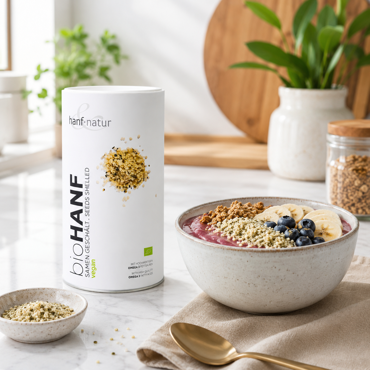 hanf & natur Bio Hanfsamen geschält neben einer Smoothie Bowl mit Banane, Blaubeeren und Granola