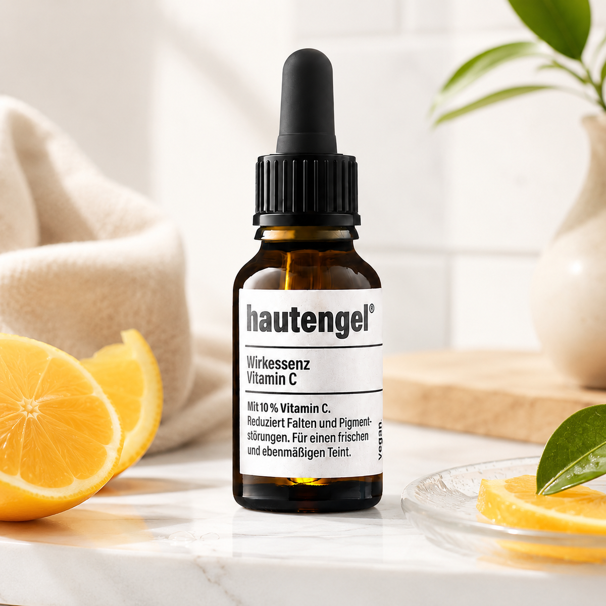 hautengel Wirkessenz Vitamin C als Lifestyle Produktbild mit frischen Zitrusfrüchten im hellen Spa Ambiente
