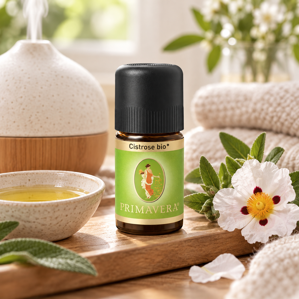 PRIMAVERA Cistrose bio ätherisches Öl in entspannter Aromapflege-Szene mit Diffuser und Cistrosenblüte