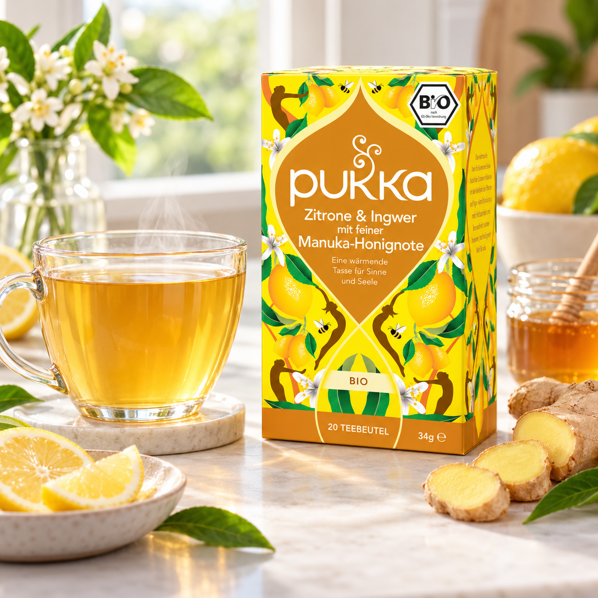 Pukka Bio-Tee Zitrone & Ingwer mit Manuka-Honignote neben einer frisch aufgebrühten Tasse Tee