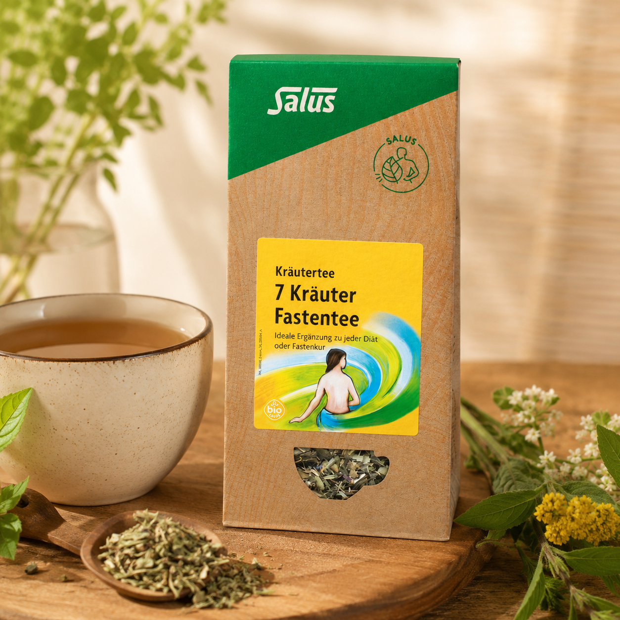 Salus 7 Kräuter Fastentee bio neben einer Tasse Kräutertee und ausgewählten Kräutern