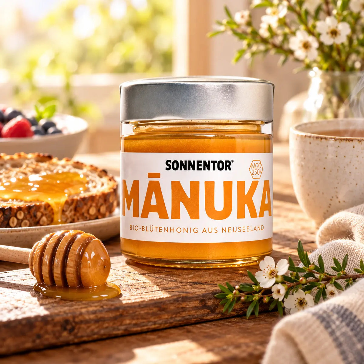 Sonnentor Manukahonig MGO 250+ beim Frühstück mit Brot, Honiglöffel und warmem Getränk