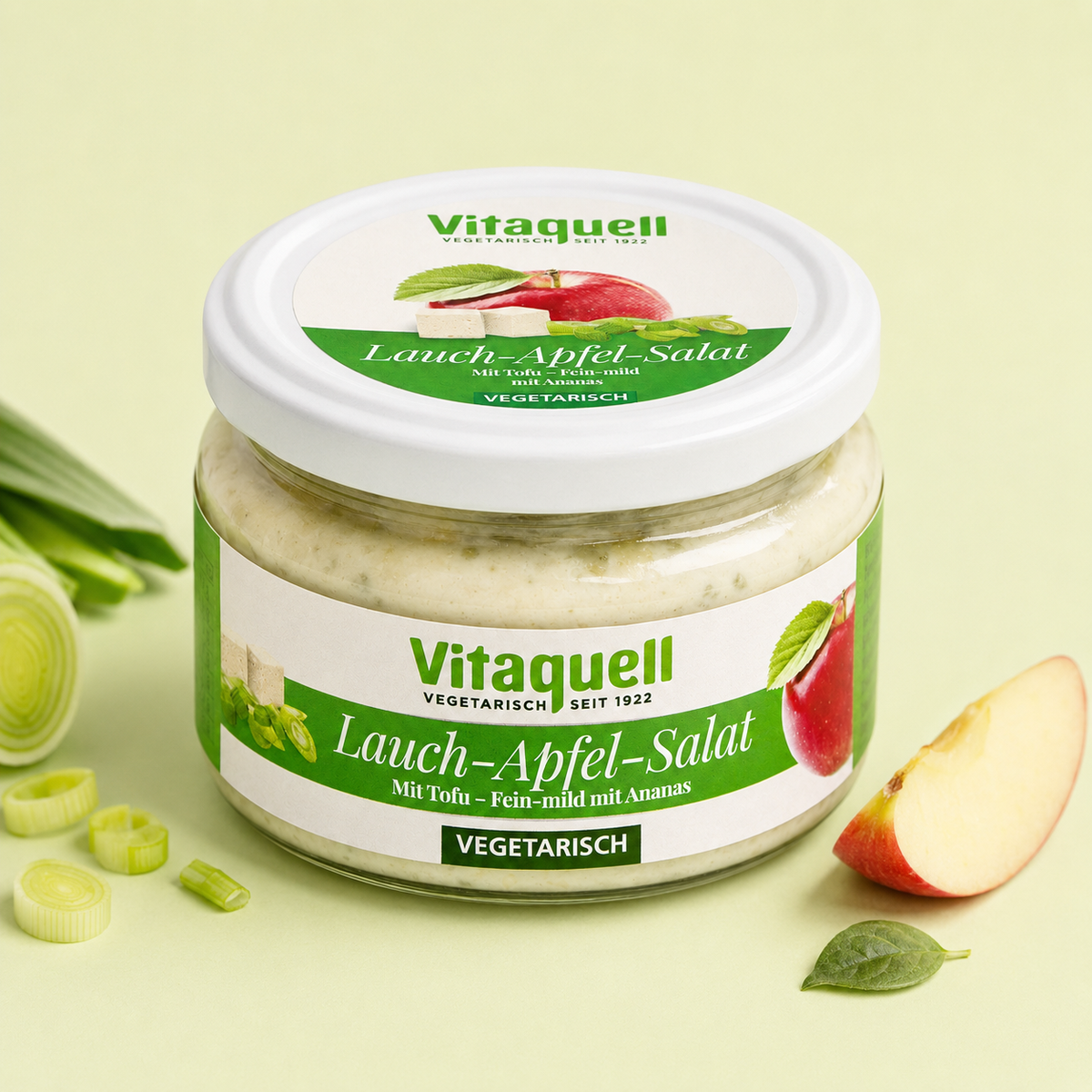 Vitaquell Lauch-Apfel-Salat im 200-g-Glas mit Apfel und Lauch auf hellgrünem Hintergrund